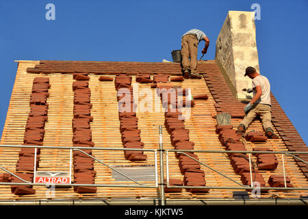 Workers on a roof. France. Stock Photo