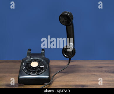 Antique old rotary dial telephone on wooden desk Stock Photo