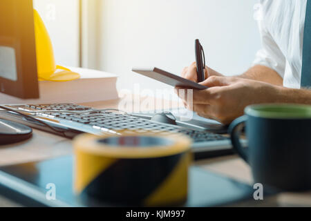 Civil engineer using smartphone in office during the construction industry project development Stock Photo