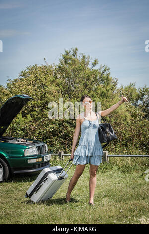 A beautiful young woman looking disappointed because her car has broken down. Stock Photo