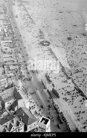 1940s view from the top of Blackpool Tower, a tourist attraction in Blackpool, Lancashire, England, which was opened to the public on 14 May 1894. Inspired by the Eiffel Tower in Paris, it is 518 feet (158 metres) tall and is the 120th tallest freestanding tower in the world. Blackpool Tower is also the common name for Tower buildings, an entertainment complex in a red-brick three-storey block comprising the tower, the ground floor aquarium and cafeteria, Tower Circus, the Tower Ballroom and roof gardens that was designated a Grade I listed building in 1973. Stock Photo