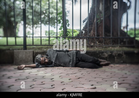 Old homeless man sleeping in the streets om Mumbai, India. Stock Photo