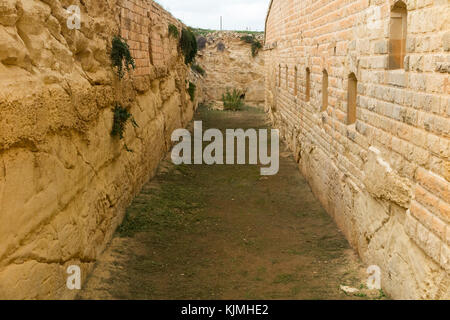 Defensive dry moat trench ditch (scarp & counter scarp) protected by counter scarp gallery & musketry loopholes / musket loop holes Fort Rinella Malta Stock Photo