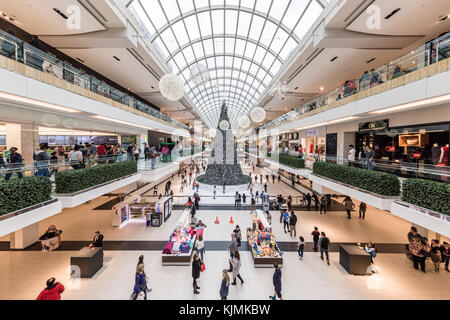 People Busy Christmas Holiday Shopping in the Galleria Shopping Mall, Giant Christmas Tree and Skate Rink visible in the distance Stock Photo