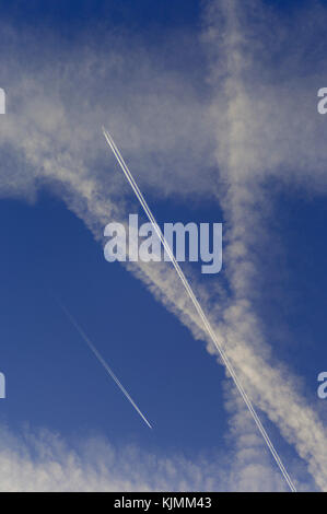 Multiple crossing contrails in a blue sky over South London. Stock Photo