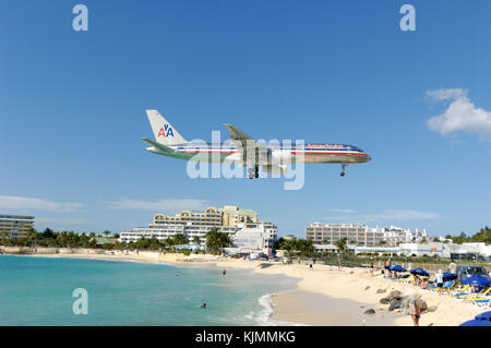 flying low on final-approach landing over Maho Beach with hotels behind Stock Photo