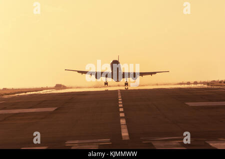 A jet airliner taking off at dusk from the runway at Sint Maarten in the Dutch Antilles. Stock Photo