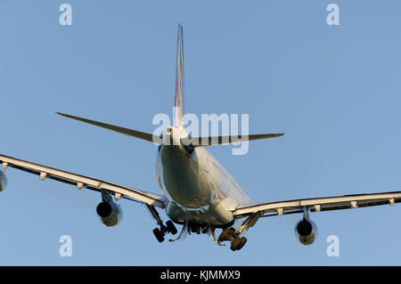 An Airbus A340 jet airliner flying away climbing after take-off with the undercarriage retracting. Stock Photo