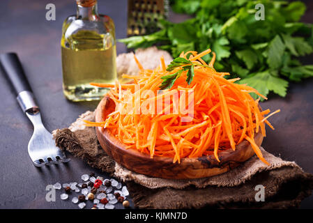 Fresh grated carrot on wooden plate Stock Photo