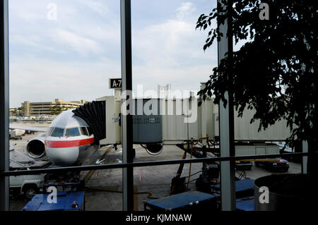 windshield of an American Airlines Boeing 777-200 ER parked at the Gate with jetway, tug and truck Stock Photo