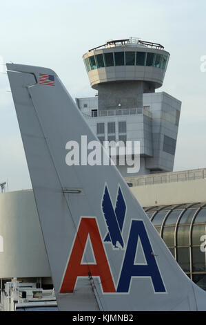 tail of an American Airlines Boeing 737-800 with the air-traffic control-tower behind Stock Photo