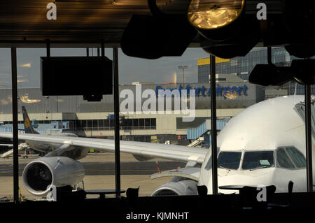 windshield of the South African Airways Airbus A340 parked at a gate and Lufthansa Boeing 737 parked behind at the terminal seen through a window Stock Photo