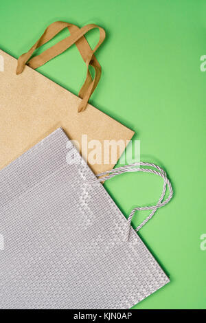 Golden and silver gift bags on green background. Flat lay Stock Photo