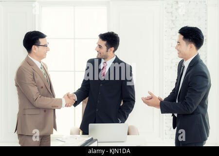 Successful job two Asian businessman shaking hands in board room when finishing up a meeting. Stock Photo