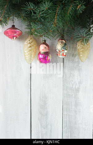Christmas or New Year's background with fir branches and old Christmas-tree toys on a white background. Rustic style, selective focus. Stock Photo