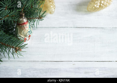 Christmas or New Year's background with fir branches and old Christmas-tree toys on a white background. Rustic style, selective focus. Stock Photo