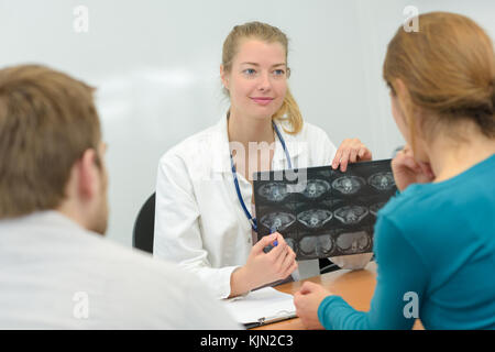 Doctor showing scan results to young couple Stock Photo