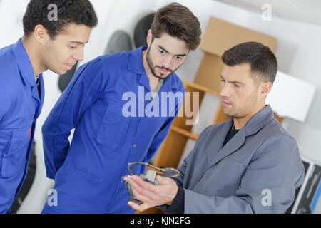 trainees and teacher with auto part studying automotive trade Stock Photo