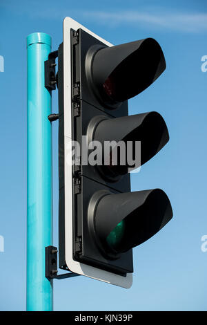 Low angle view of UK traffic lights against a clear blue sky. Stock Photo