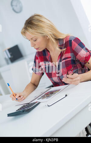 middle aged female working on at desk at home Stock Photo