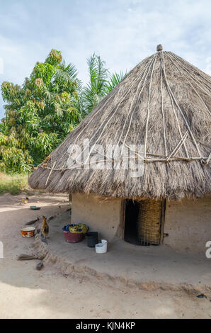 Beautiful traditional thatched round mud and clay hut in rural village of Guinea Bissau, West Africa Stock Photo