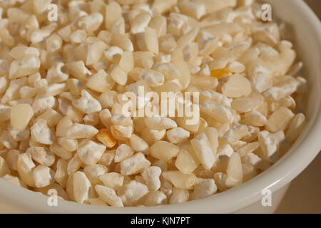 A bowl of dried white hominy, corn, called  maiz trillado or Morocho Partido in Spanish Stock Photo