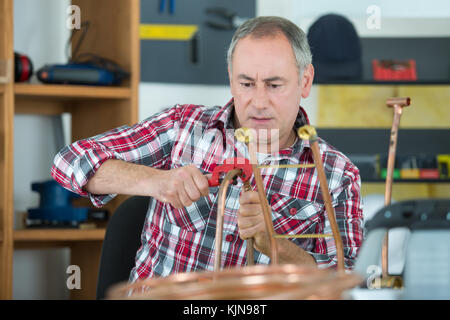Man working on copper pipe Stock Photo