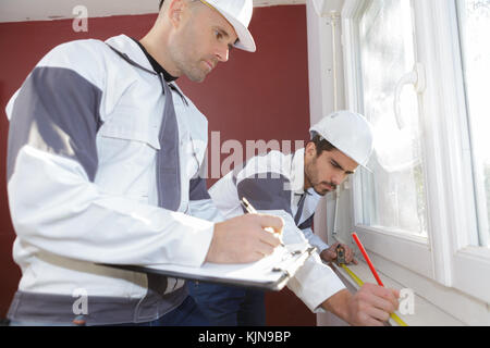 construction worker using measuring tape in a new house Stock Photo