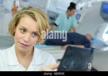 female specialist checking brain tomography results Stock Photo