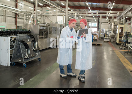 happy two factory workers in uniform examining sample Stock Photo