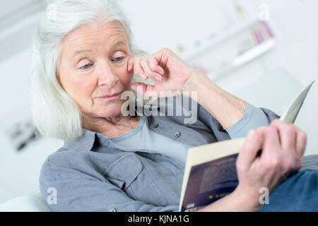 Elderly lady reading novel Stock Photo