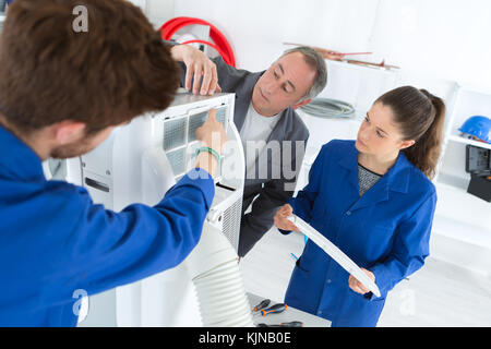 air conditioning apprentices working on a compressor Stock Photo