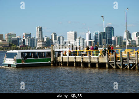 A Swan River ferry arriving at Elizabeth Quay ferry terminal with the city skyline beyond, Perth, Australia. Stock Photo