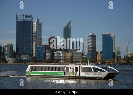 A Swan River ferry arriving at Elizabeth Quay ferry terminal with the city skyline beyond, Perth, Australia. Stock Photo
