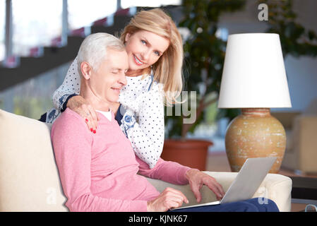 Shot of a happy mature couple using laptop while relaxing at home together. Stock Photo
