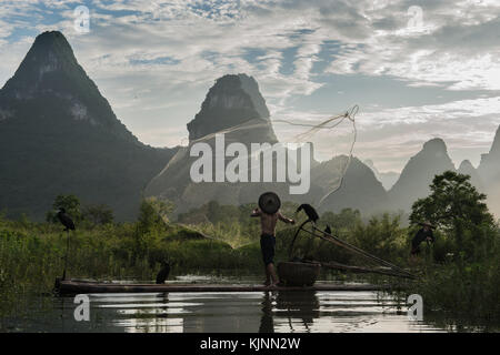Cormorant fishermen in China throwing net fish Stock Photo