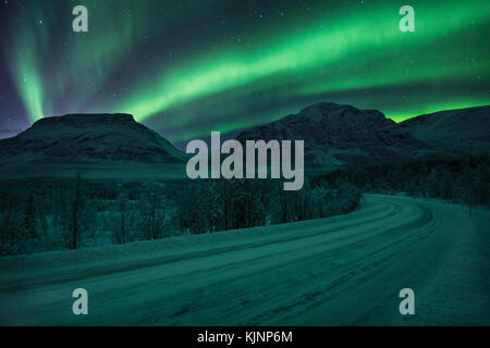 Icy road through northern Norway, under the northern lights Stock Photo