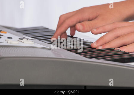 Two hands playing an electronic keyboard. Stock Photo