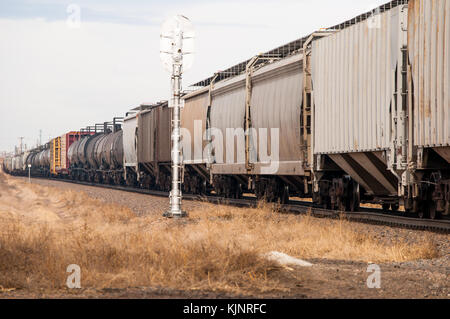 Early morning train in rural Colorado, USA passing a railroad signal. Stock Photo