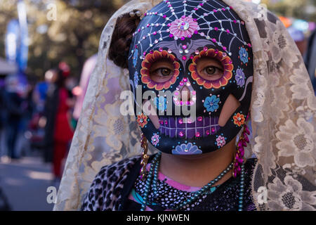 Girl wearing colorful skull mask and lace veil for Dia de Los Muertos/Day of the Dead in San Antonio, TX Stock Photo