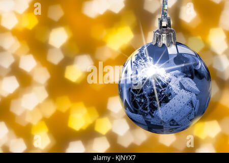 Christmas tree with plenty of presents in mirror from shiny ball. Hanging blue bauble with star on yellow abstract background. Stock Photo
