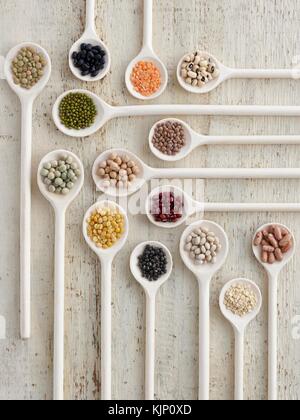 Pulses on wooden spoons, overhead view. Stock Photo