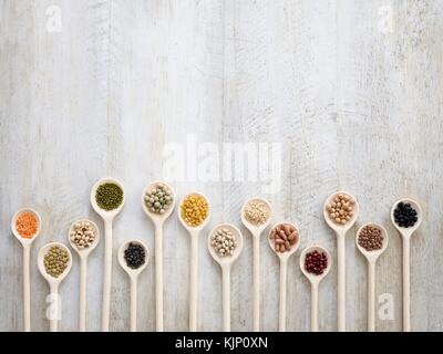 Pulses on wooden spoons, overhead view. Stock Photo