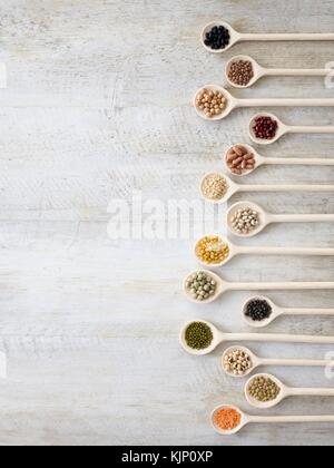 Pulses on wooden spoons, overhead view. Stock Photo