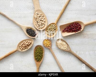 Pulses on wooden spoons, overhead view. Stock Photo