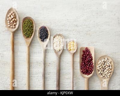 Pulses on wooden spoons, overhead view. Stock Photo