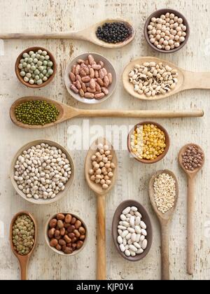 Pulses on wooden spoons, overhead view. Stock Photo