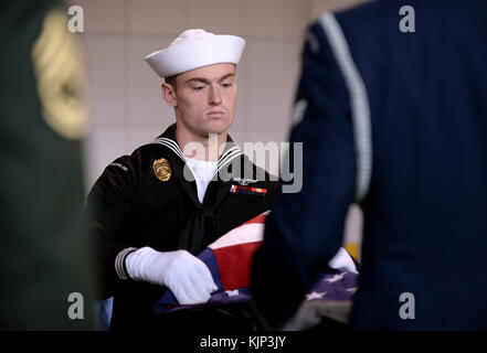 Masters and Arms 3rd Class Cody Pacher, an Offutt Air Force Base Honor Guard member, folds the U.S. flag during a flag folding ceremony at the Durham Western Heritage Museum in downtown Omaha, Neb. November 10, 2017. Pacher was participating in a Veterans Day ceremony hosted by the Union Pacific Corporation to honor past and present veterans. A newly unveiled U.P. No. 1943 locomotive with a custom military services paint scheme also traveled to the museum for the ceremony. (U.S. Air Force photo by Delanie Stafford) Stock Photo