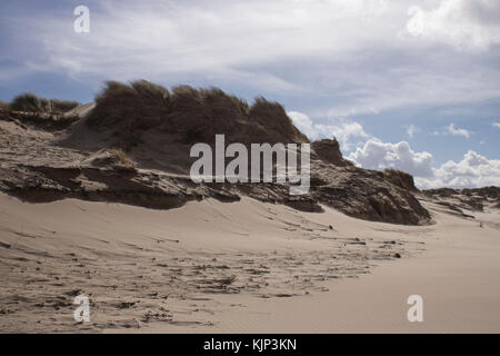 sand dunes with grass blowing in the sea breeze at formby point Stock Photo