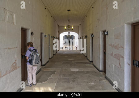 A tourist is peeping into a cell in the former Separate Prison at the Port Arthur Historic Site Stock Photo